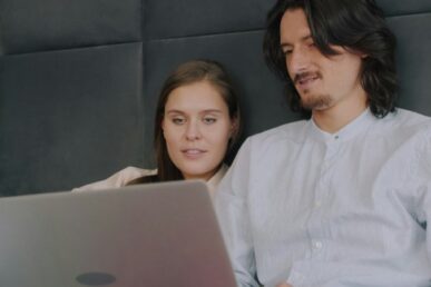 Couple attending online marriage counseling together on a laptop at home